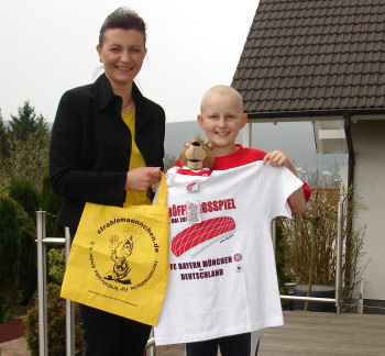 Strahlemaennchen uberreicht ein T-Shirt vom FC Bayern M�nchen